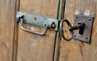 grosse clef dans serrure d'une porte en bois 