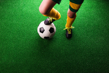 Plakat Unrecognizable little football player against green grass, studi