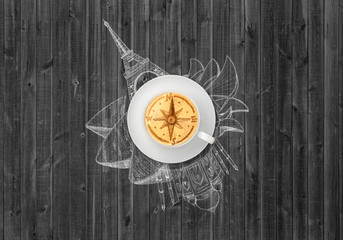 Cup of cappuccino coffee with image compass and hand-drawn sights
