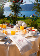 Set the table with breakfast on the green lawn in front of the lake