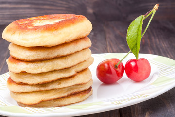 fritters on a plate with sweet cherry isolated white background