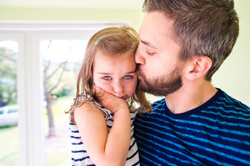 Close up of hipster father holding his crying daughter