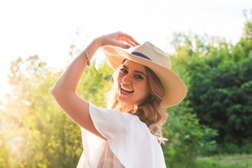 Obraz premium fashion, happiness and lifestyle concept - beautiful woman in hat enjoying summer outdoors.
