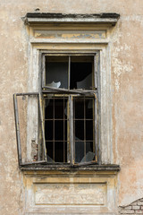 Obraz na płótnie Canvas Old broken window on an abandoned old abandoned building