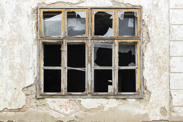 Fototapeta na wymiar Old broken window on an abandoned old building
