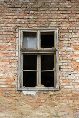 Fototapeta na wymiar Old broken window on a old abandoned brick wall house