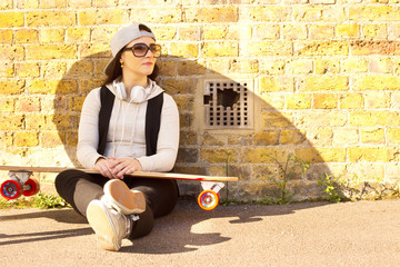 Fototapeta na wymiar young woman sitting relaxing with her skateboard