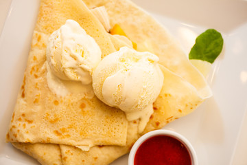 Pancake with ice cream and strawberry sauce