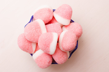 Pink jellies or marshmallows with sugar in bowl