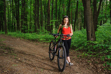 Fototapeta premium Girl riding a bike in the woods