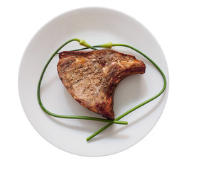Pork chop with garlic scapes on a plate