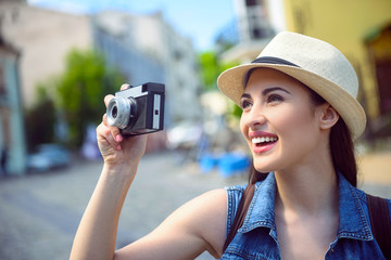 Happy girl photographing city with joy