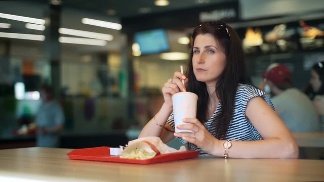 Young women eating fast food and drinkink milk cocktail