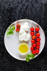 Caprese Salad ingredients: cherry Tomatoes, olive oil and Mozzar