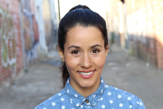 Young hispanic woman with cute freckles and a beautiful smile