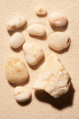 Fototapeta na wymiar Collection of ten white toned sea stones on sand