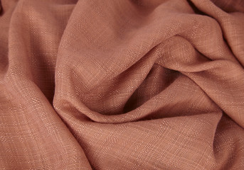 Fabric textures - a close up of orange scarf material folds to form a page background