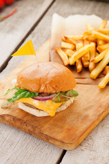 Delicious homemade hamburger with french fries on wooden vintage table