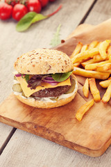 Delicious homemade hamburger with french fries on wooden vintage table