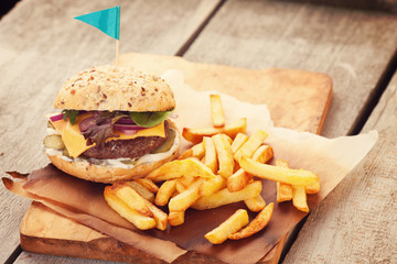 Delicious homemade hamburger with french fries on wooden vintage table