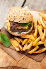 Delicious homemade hamburger with french fries on wooden vintage table