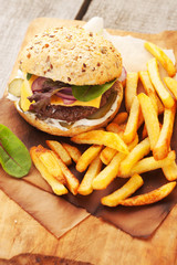 Delicious homemade hamburger with french fries on wooden vintage table
