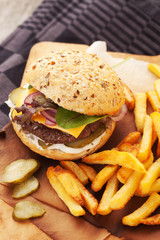 Delicious homemade hamburger with french fries on wooden vintage table