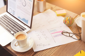Notebook with mug of hot beverage on table