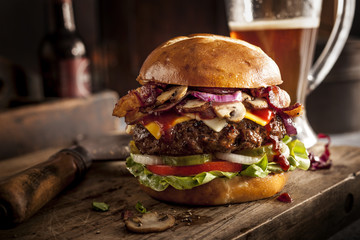 Large cheeseburger on bar with beer