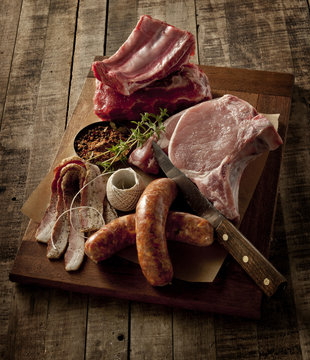 Wooden board with a selection of raw meats