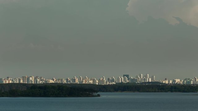 A lake and a city on a horizon and a cloudy sky time lapse stock footage