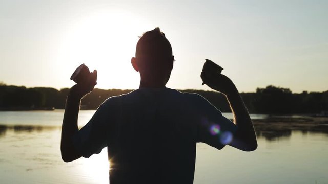 игра на маракасах или кашиши на фоне неба в закате