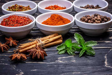 Colorful aromatic Indian spices and herbs on an old oak wooden b