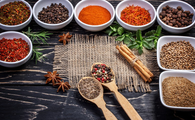 Colorful aromatic Indian spices and herbs on an old oak wooden b