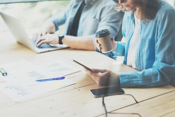 Coworkers team researching process in modern loft.Project managers working.Holding tablet female hand.Young business crew  with new startup office.Risk management .Blurred,film effect.