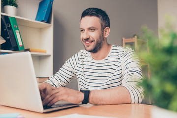 Smart happy successful  bearded businessman working with laptop