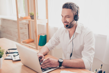 Portrait of handsome young worker with head-phones and laptop