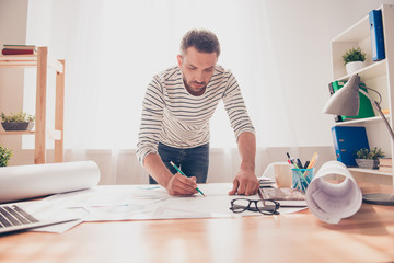 Concentrated young engineer working on plane of new house