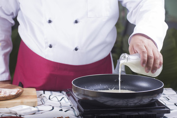 Chef pouring fresh milk to the pan
