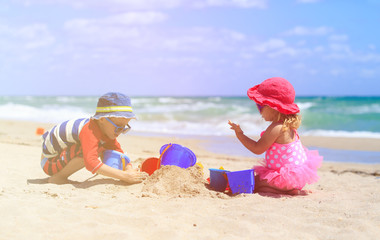 kids play with sand on summer beach