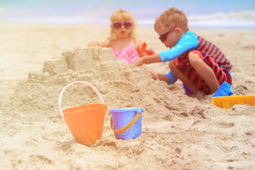 kids play with sand on summer beach