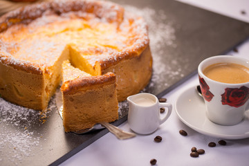Käsekuchen und eine Tasse Kaffee mit Milch