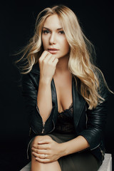 Fototapeta premium very beautiful girl sitting on a chair in the studio in a leathe
