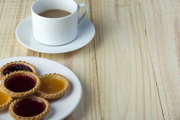 Plate of fresh jam tarts and a cup of coffee