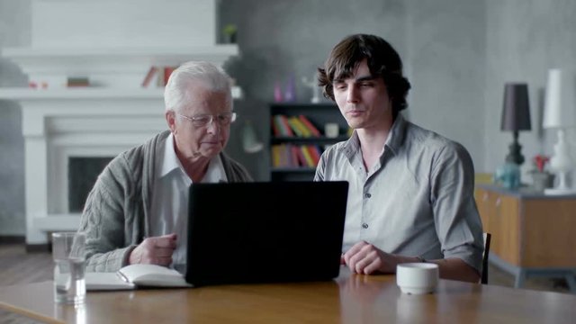 Grandson Teaching grandfather How to Use a laptop PC