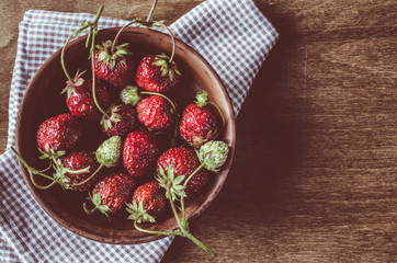 Fresh ripe organic strawberry on wooden background. Vintage rustic style and color tinting.