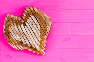 Heart shaped sliced bread on pink background