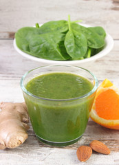 Ingredients and fresh cocktail from spinach on wooden background, healthy nutrition