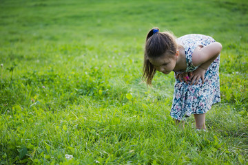 Fototapeta premium one little girl with magnifying glass outdoors in the day time