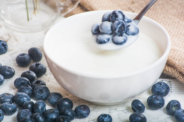 Juicy and fresh blueberries on the spoon with yogurt